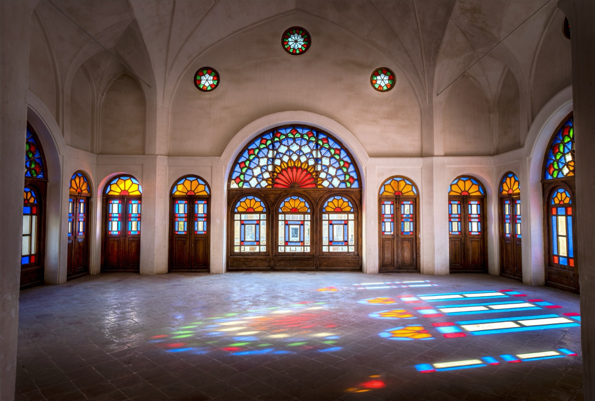 Hall with stained-glass windows and coloured light (Kashan region; building to confirm)