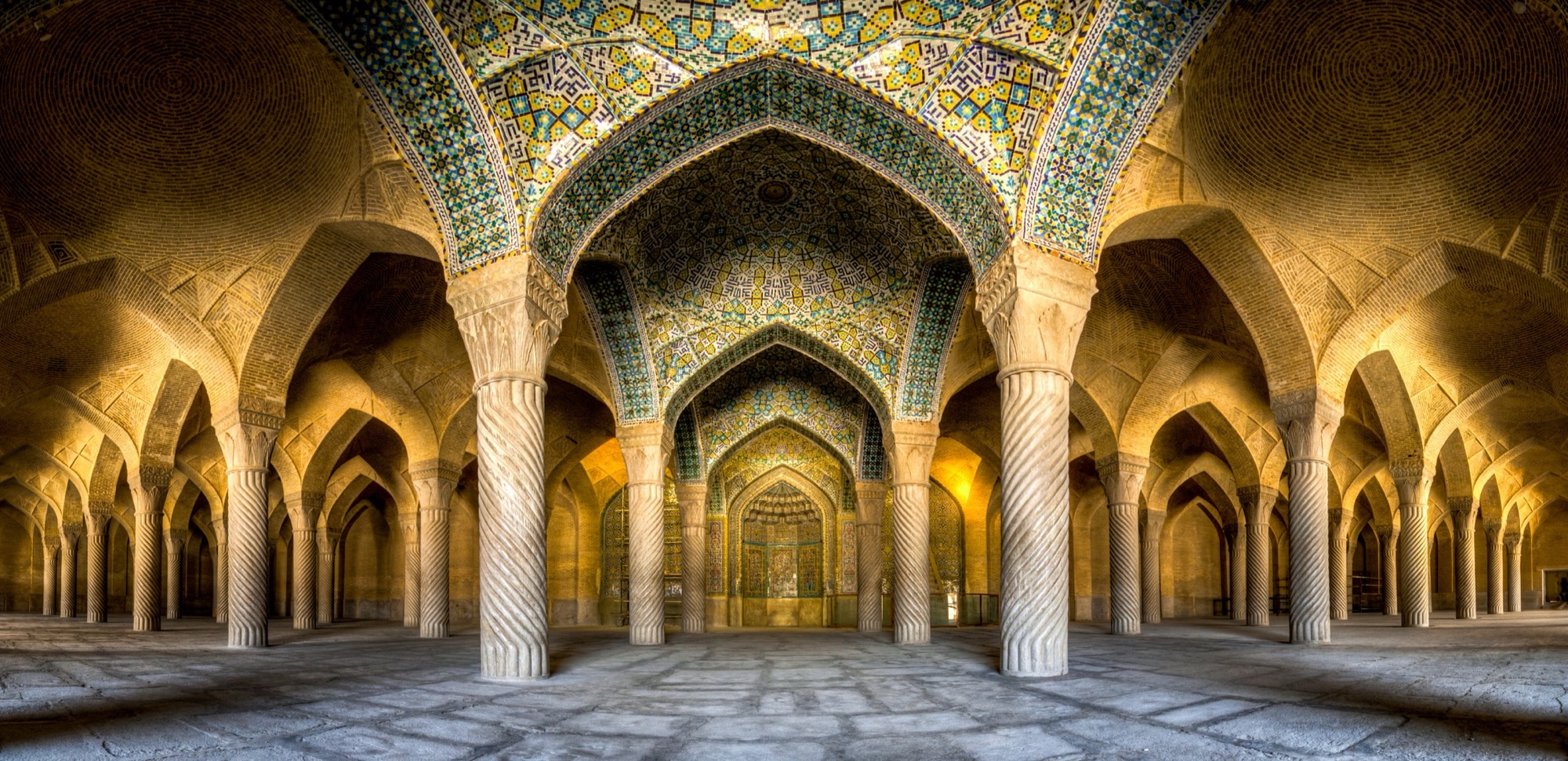 La salle de prière de la mosquée Vakil, à Chiraz : des rangées de colonnes torsadées sous des voûtes de brique.